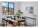 Dining room features wood table and modern chairs, along with natural light from a large window at 2078 S Holly St # 3, Denver, CO 80222