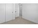 A hallway with carpeting, and multiple bright white doors, creating a sense of spaciousness at 2078 S Holly St # 3, Denver, CO 80222