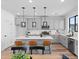 A kitchen with an island with bar seating and modern pendant lighting above, set against a neutral color palette at 2078 S Holly St # 3, Denver, CO 80222