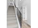 Carpeted staircase with black metal railing leading to upper level with light wood flooring and white doors at 2078 S Holly St # 3, Denver, CO 80222