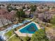 Aerial view of the neighborhood pool, surrounded by mature trees, a grassy lawn, and neighboring townhomes at 1842 S Pitkin Cir # A, Aurora, CO 80017