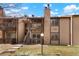 Exterior view of the home featuring a stone chimney, balcony, and well-maintained lawn at 1842 S Pitkin Cir # A, Aurora, CO 80017