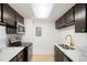 Modern kitchen features dark cabinetry, white countertops, stainless steel appliances, and updated fixtures at 1842 S Pitkin Cir # A, Aurora, CO 80017