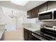 Modern kitchen features stainless appliances, dark cabinets with gold hardware, and opens to a dining area at 1842 S Pitkin Cir # A, Aurora, CO 80017