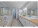 Bright bathroom featuring double sink vanity with wood countertop, large tub and separate glass shower at 2364 S Harlan St, Lakewood, CO 80227