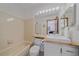 Bright bathroom with a bathtub, wood vanity, toilet and ample counter space at 2364 S Harlan St, Lakewood, CO 80227