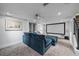 Basement living room area featuring cozy blue sectional sofa, projector, and a large white screen at 2364 S Harlan St, Lakewood, CO 80227