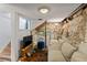 Basement features a cozy seating area and stone wall accents, creating a rustic and inviting recreational space at 1047 Meade St, Denver, CO 80204