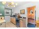 Eat-in kitchen area featuring tile flooring, modern lighting, stainless steel appliances, and sink with wooden cabinets at 1047 Meade St, Denver, CO 80204