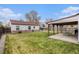 Large grassy backyard with a covered patio provides ample space for recreation and entertaining at 1293 S Perry St, Denver, CO 80219