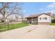 Charming single-story home with a stone facade and a well-maintained front yard and long driveway at 1293 S Perry St, Denver, CO 80219