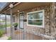 Close-up of stone-clad front porch with security door, large window, and metal railing at 1293 S Perry St, Denver, CO 80219