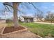 Ranch-style home with a large tree, green grass, and manicured landscaping in a suburban neighborhood at 1293 S Perry St, Denver, CO 80219