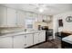Bright kitchen with white cabinets, marble countertops, stainless steel appliances, and hardwood floors at 1293 S Perry St, Denver, CO 80219