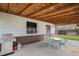 Covered patio area with outdoor furniture and a grill, perfect for entertaining at 1293 S Perry St, Denver, CO 80219