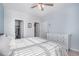 Sunlit bedroom with white dresser, ceiling fan, and organized closet space through the door at 17297 Wilde Ave # 205, Parker, CO 80134