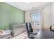 Bedroom featuring a gray crib, modern window blinds, and a green accent wall at 17297 Wilde Ave # 205, Parker, CO 80134