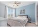 Cozy bedroom featuring a ceiling fan, bright window and a light blue accent wall at 17297 Wilde Ave # 205, Parker, CO 80134