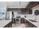 Modern kitchen with stainless steel appliances, dark cabinets, and a bright white countertop at 17297 Wilde Ave # 205, Parker, CO 80134