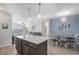 Open-concept living and dining area with a kitchen island and modern lighting fixtures at 17297 Wilde Ave # 205, Parker, CO 80134