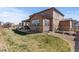 Spacious backyard with lush green grass and a partially covered patio at 7251 S Old Hammer Way, Aurora, CO 80016