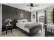 Cozy bedroom featuring a dark accent wall, ceiling fan, and bright window at 7251 S Old Hammer Way, Aurora, CO 80016