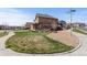 Two-story home with a covered front porch, green grass, professional landscaping, and a corner lot at 7251 S Old Hammer Way, Aurora, CO 80016