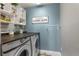 Charming laundry room with modern appliances, blue walls, and decorative elements at 7251 S Old Hammer Way, Aurora, CO 80016