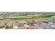 Aerial view of a suburban neighborhood with a pond and golf course in the background at 15484 E 115Th Ave, Commerce City, CO 80022