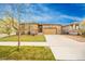 Attractive home with a lush lawn, stone accents, and a wide driveway leading to a two-car garage at 15484 E 115Th Ave, Commerce City, CO 80022