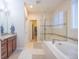 Luxurious main bathroom featuring a soaking tub, frameless shower, and dual vanities at 15484 E 115Th Ave, Commerce City, CO 80022