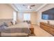 Well-lit main bedroom with a tray ceiling, large window, and custom wood dresser at 15484 E 115Th Ave, Commerce City, CO 80022