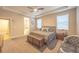 Spacious main bedroom showcasing plush carpeting, tray ceilings, and a seating area at 15484 E 115Th Ave, Commerce City, CO 80022