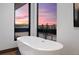 Bright bathroom featuring soaking tub with a stunning window view of mountains at sunset at 310 N Fuller Placer Rd, Breckenridge, CO 80424