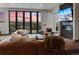 Inviting living room with fireplace, large windows boasting mountain views, and leather sectional at 310 N Fuller Placer Rd, Breckenridge, CO 80424