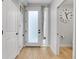 Bright entryway with wood floors, white door, side window, coat closet, and view to the powder room at 4232 Jason St # 7, Denver, CO 80211