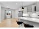 Stylish kitchen and dining area featuring a breakfast bar, sleek appliances, and hardwood flooring at 4232 Jason St # 7, Denver, CO 80211