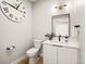 A sleek powder room features modern fixtures, a large round mirror, and a decorative wall clock at 4232 Jason St # 7, Denver, CO 80211