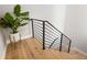 A modern staircase features wood treads, a black metal railing, and a decorative potted plant on the landing at 4232 Jason St # 7, Denver, CO 80211