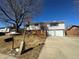 Charming two-story home featuring a large front yard, deck and a two car garage on a sunny day at 1419 S Terry St, Longmont, CO 80501