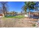 Spacious backyard featuring green grass, mature trees, and a storage shed at 2826 S Lamar St, Denver, CO 80227