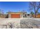 Ranch-style home with an orange garage door and a rock-covered front yard at 2826 S Lamar St, Denver, CO 80227