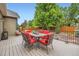 Outdoor deck and patio space is complete with a dining set, red cushions, and lush landscaping at 21107 Hawthorne Ln, Parker, CO 80138