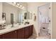 Bathroom boasts double sinks, dark wood cabinets, framed mirror, and opens to tiled shower at 21107 Hawthorne Ln, Parker, CO 80138