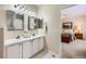 Well-lit bathroom with a double sink vanity, white cabinets, and a view into the Primary bedroom at 21107 Hawthorne Ln, Parker, CO 80138