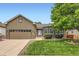 Charming home features a well-manicured lawn, mature tree and a two-car garage at 21107 Hawthorne Ln, Parker, CO 80138