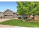 Charming home features a well-manicured lawn, mature tree and beautiful stone accents at 21107 Hawthorne Ln, Parker, CO 80138