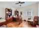 Comfortable home office with beautiful wood floors, built-in shelves, a ceiling fan, and natural light from the window at 21107 Hawthorne Ln, Parker, CO 80138