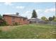 Large backyard with a well-maintained lawn and view of the brick home at 3285 S Delaware St, Englewood, CO 80110