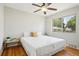 Bright bedroom with hardwood floors, ceiling fan, and a sunlit window looking out to the neighborhood at 3285 S Delaware St, Englewood, CO 80110